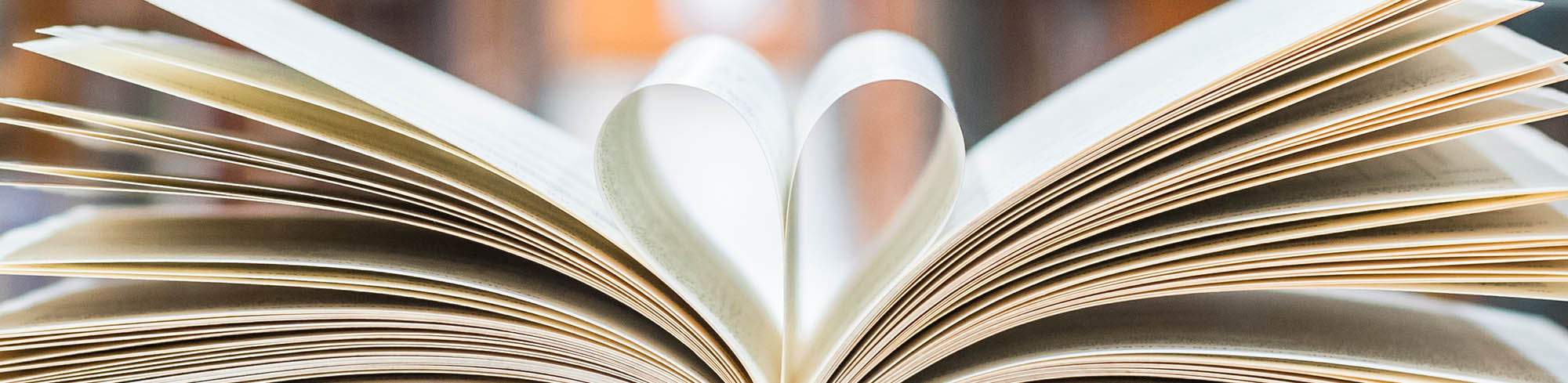 An open book with pages folded in a heart shape