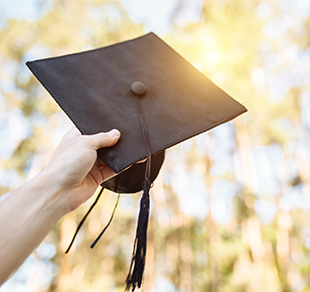 graduation cap held up to the sun