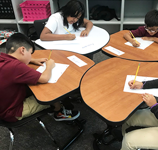 Students working at their desks on a writing assignment